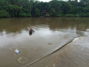 Ribeirinhos remam até bem perto da embarcação para receber doações dos passageiros, que jogam roupas e alimentos dentro de sacos plásticos.