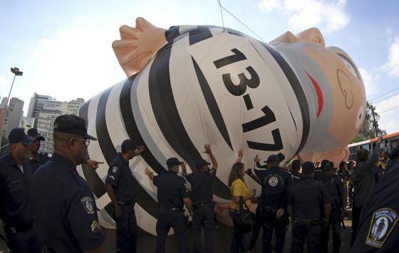 Integrantes da polícia metropolitana removem boneco inflável que satiriza Lula.