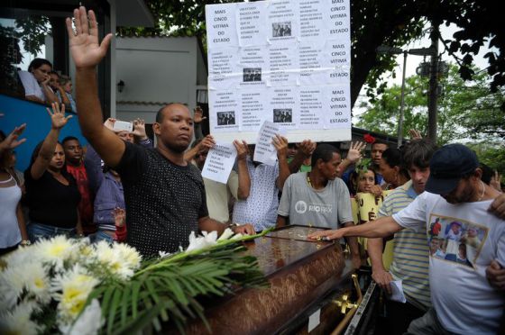 Cartaz carregado por amigos e familiares das vítimas no dia do funeral: