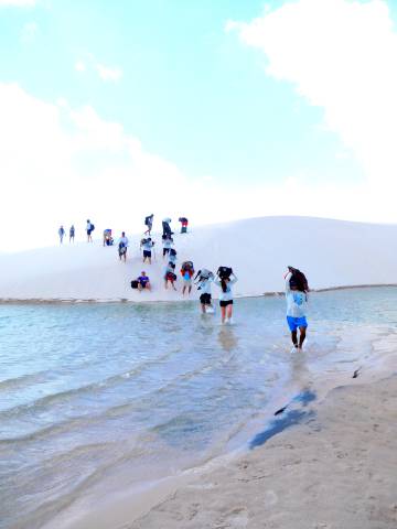 Turistas cruzam uma lagoa.