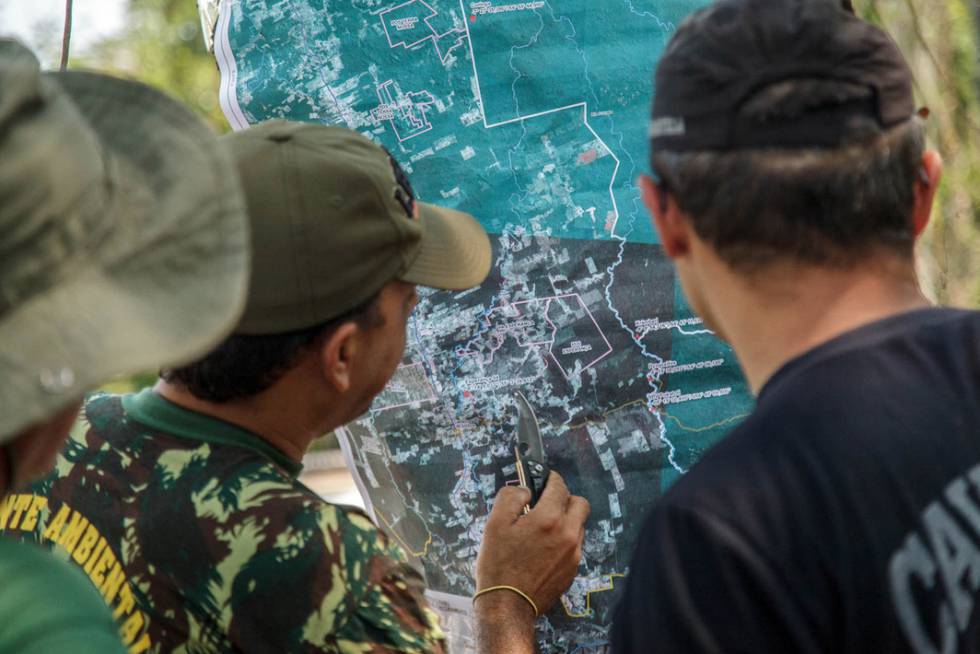 Servidores do IBAMA e indígenas observam o mapa dos arredores da Terra Indígena Mekrãgnoti. Servidores do IBAMA e indígenas observam o mapa dos arredores da Terra Indígena Mekrãgnoti.