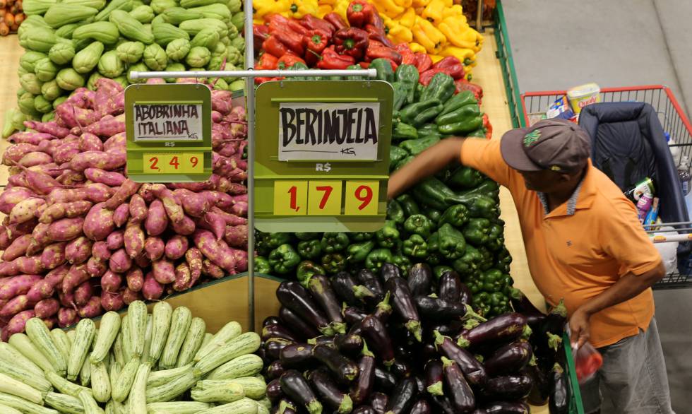 Consumidor escolhe legumes em um supermercado de São Paulo.