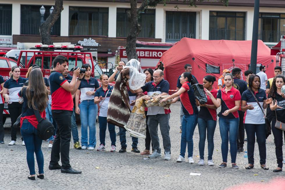 Voluntários da Igreja Universal fotografam a si mesmos enquanto doam aos desabrigados