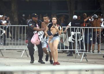 Mãe tenta proteger a filha em distúrbio no entorno do Maracanã.