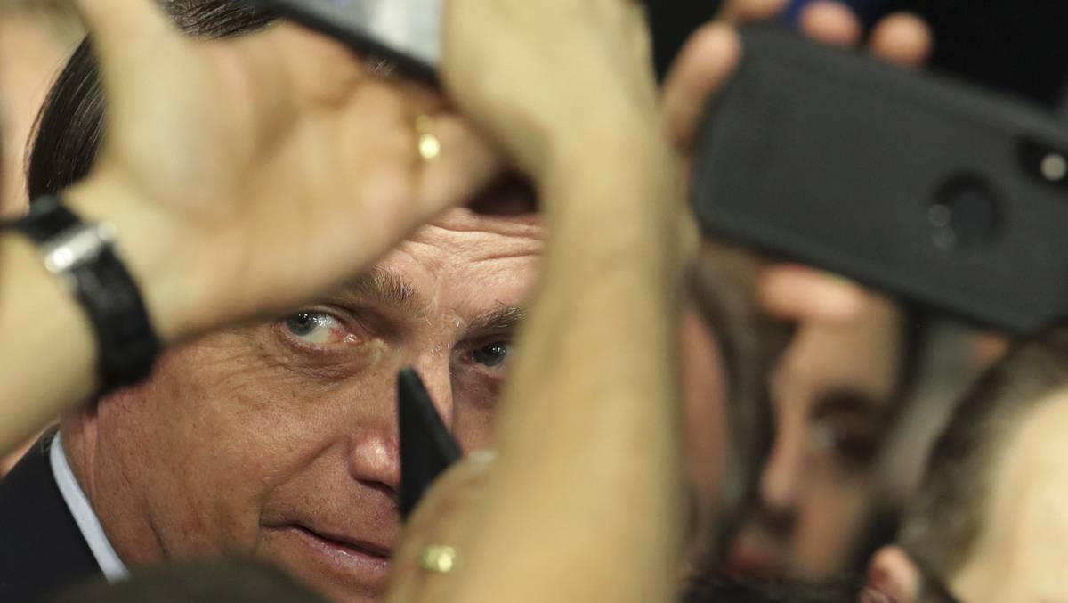 O presidente Jair Bolsonaro tira fotos com seus apoiadores em Brasília, no dia 21 de maio.