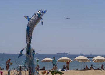 L’escultura d’un dofí feta amb residus de la revetlla decora la platja del Somorrostro