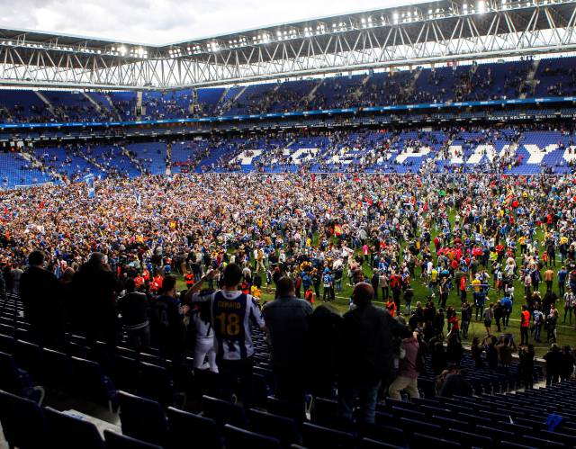 Aficionats de l’Espanyol a la gespa de l’estadi de Cornellà celebrant la classificació del club a la Lliga Europa, el passat 19 de maig.