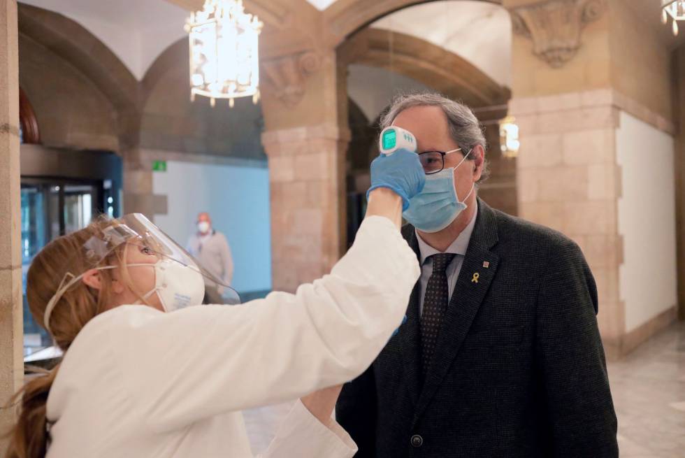 Quim Torra es fa prendre la temperatura a l'entrada al Parlament.