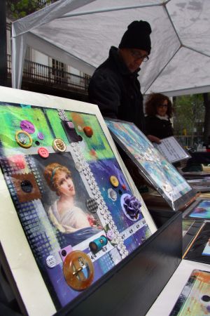 Alejandro vende sus pinturas acrílicas realizadas con objetos de costura en un puesto de la Rambla. Alejandro vende sus pinturas acrílicas realizadas con objetos de costura en un puesto de la Rambla.