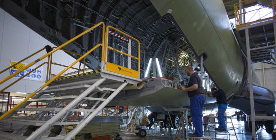 Los trabajadores prueban el portalón de carga tras haber pasado el avión por la fase de encendido eléctrico. La zona interior aún carece de revestimientos.