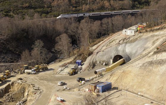 Un tren circula junto a las obras del nuevo túnel de O Padornelo tras salir del actual, que se seguirá usando para la alta velocidad.