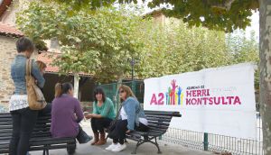 Unes veïnes al costat de la ikastola on hi ha un cartell de la consulta. Al costat de la plaça del poble, hi ha el local particular, al costat del 'batzoki', on es farà la votació.