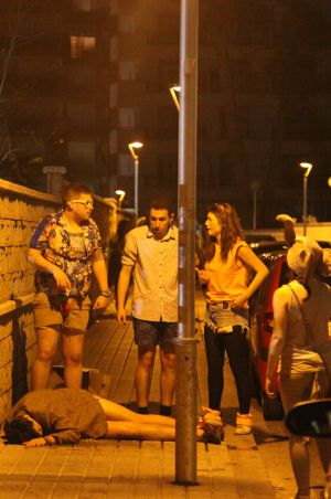 Un jove estirada sota els efectes de l'alcohol en un carrer de Salou.