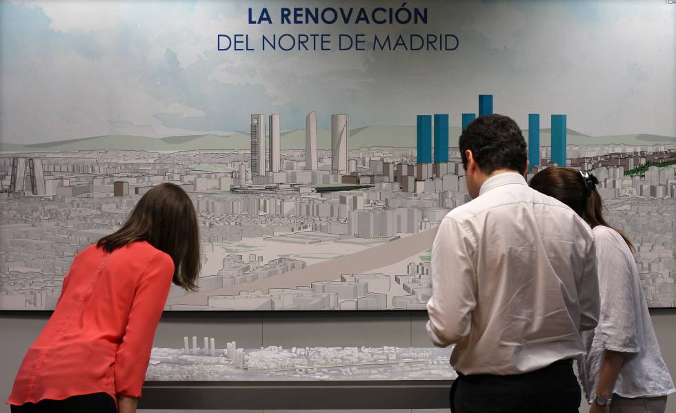 Varias personas observan una maqueta del proyecto Castellana Norte.