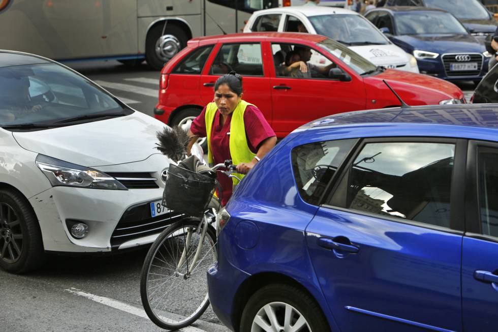 Una ciclista intenta cruzar entre los vehículos en  el día europeo sin coches.