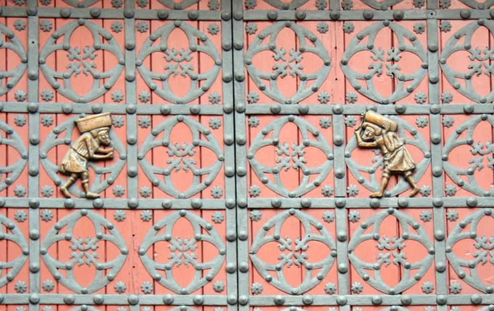 Detalle de la porta principal de Santa María del Mar, amb dues 'bastaixos' que porten sobre les espatlles les pedres des de la pedrera real de Montjuïc.