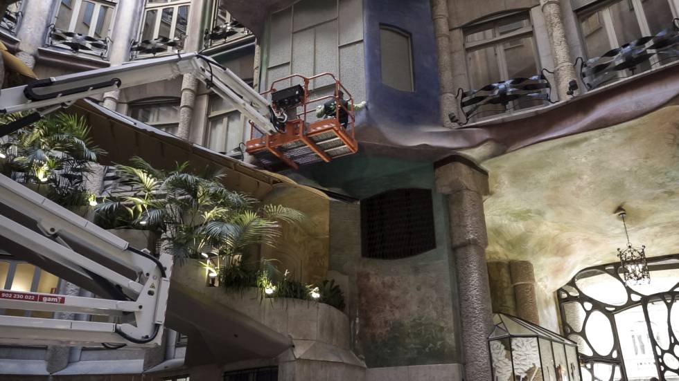 Dos restauradors intervenen en les pintures de Clapés d'un dels patis de la Pedrera.