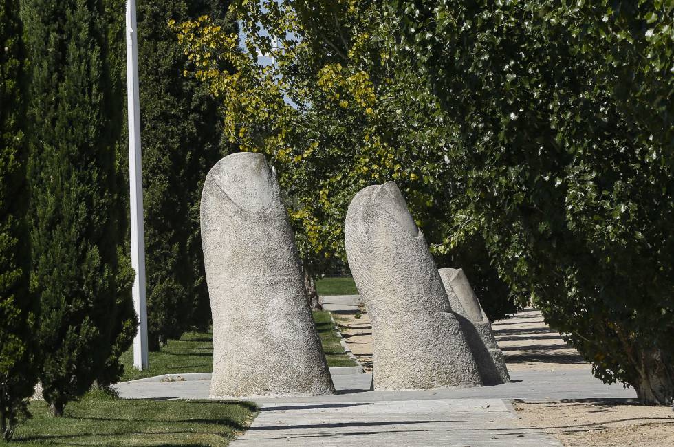 Escultura de cinco dedos gigantes en la zona verde.