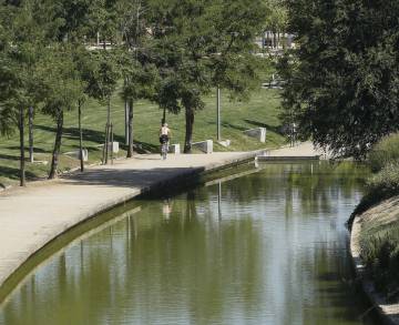 Un ciclista pasea por un sendero del parque.