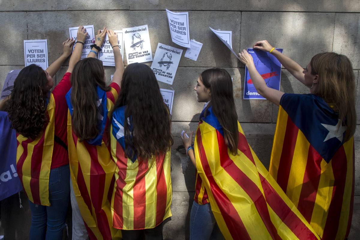GRA109. BARCELONA, 24092017.- Varias estudiantes enganchan carteles en la pared de la Universidad de Barcelona durante el inicio de la "Maratón por la democracia" que desarrolla acciones delante de las sedes de ayuntamientos por toda Cataluña para confeccionar "material de campaña para defender el referéndum del 1-O". EFEQuique García