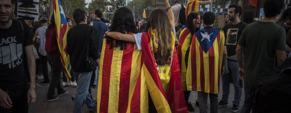 Two girls, one with a Catalan independence flag wrapped on her shoulders walks together with another one with a Spanish flag as demonstrators gather in downtown Barcelona, Spain, Tuesday Oct. 3, 2017. Thousands of people are demonstrated in Barcelona in protest at what they say was police brutality during a referendum on Catalonia's secession from Spain that was previously declared illegal by Spain's Constitutional Court.(AP PhotoSanti Palacios)