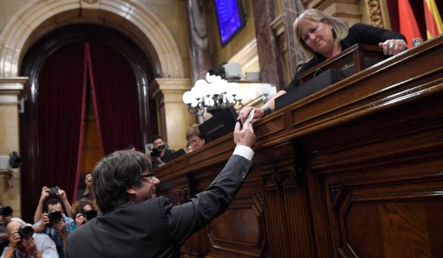 El presidente de la Generalitat, Carles Puigdemont, entrega su voto este viernes en el Parlament.