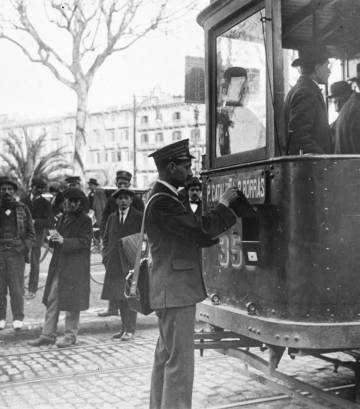 Carter recollint la correspondència dipositada en una bústia d'un tramvia a la parada de la plaça de Catalunya, el 1915.