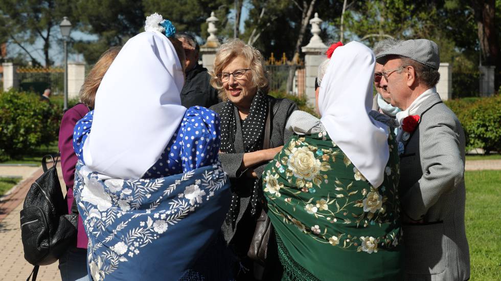 La alcaldesa Manuela Carmena conversa con unos chulapos en el Parque del Oeste.