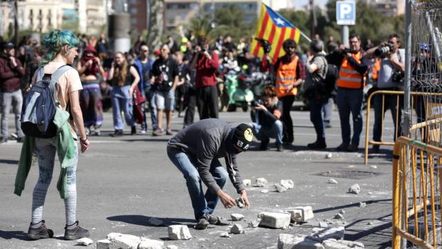 Manifestantes independentistas cogen piedras en la calle Tarragona.