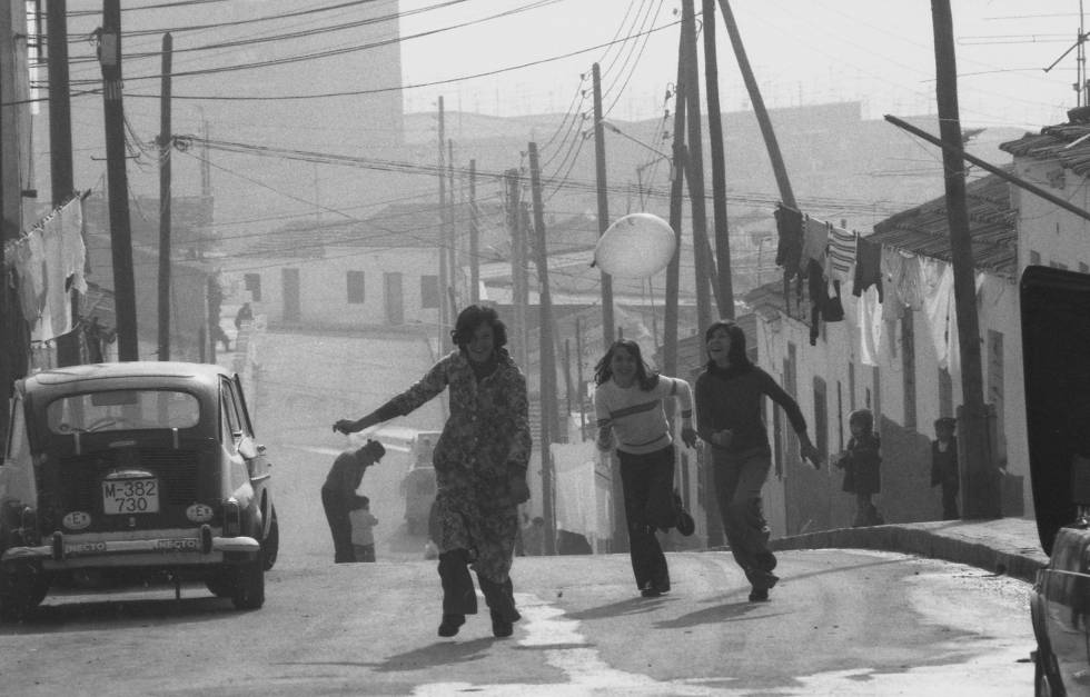 Tres jóvenes corren en el barrio de Palomeras Centro, en 1975.