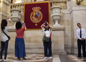 Un auxiliar de sala en el Palacio Real, junto a varias turistas.rn