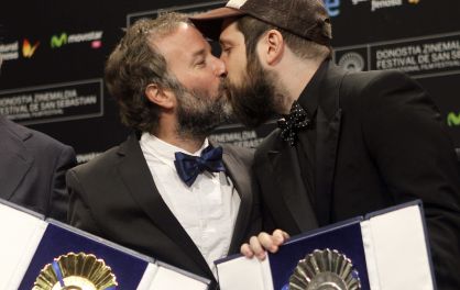 Carlos Vermut, a la derecha, y el productor Pedro Hernández se besan tras su triunfo en el Festival de San Sebastián con 'Magical girl'.
