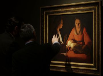 Visitantes contemplan la obra 'El recién nacido' de De La Tour, en el Prado.