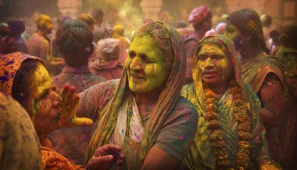 Viudas hindús se pintan la cara con polvos de colores en el templo Gopinath.