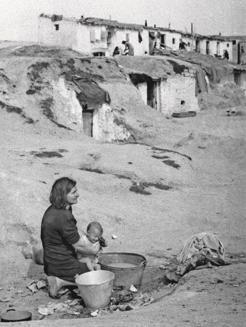 Una mujer baña a su hijo en un balde, en un barrio de chabolas a las afueras de Madrid en abril de 1940.