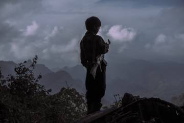 Chi Vang tiene 10 años y ya sabe manejar perfectamente su Kalashnikov.