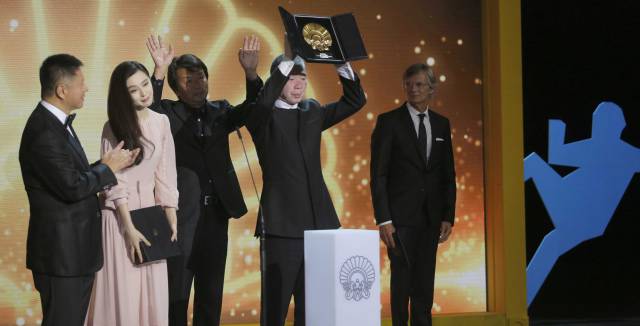 El director Xiaogang Feng alza la Concha de Oro, acompañado de su equipo, y de la actriz Fan Bingbing, con la Concha de Plata.