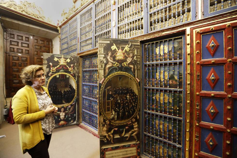 La directora de la biblioteca de la Universidad de Salamanca, Margarita Becedas, junto a los armarios de la sala de manuscritos, decorados con dibujos de cómo se impartían las clases.