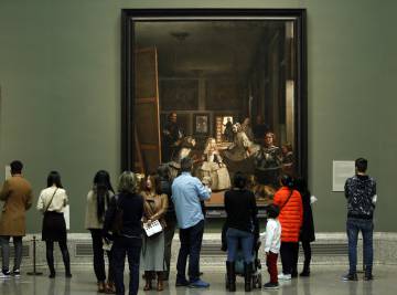 Visitantes observando "Las Meninas", en la sala de Velázquez del Museo del Prado.