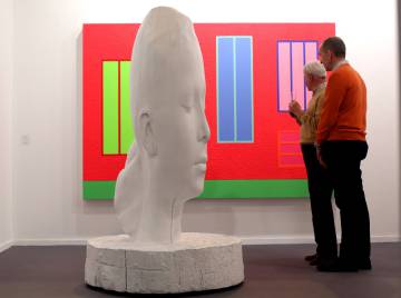 Dos visitantes observan un cuadro de Peter Halley ante una escultura de Jaume Plensa.