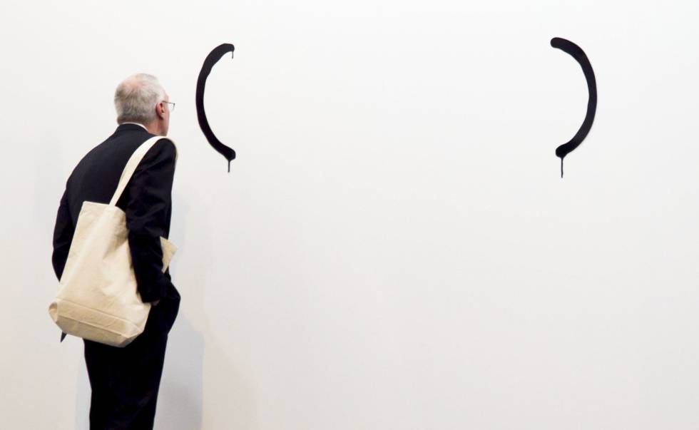 Un hombre observa una obra de la Galeria Luis Adelantado. 