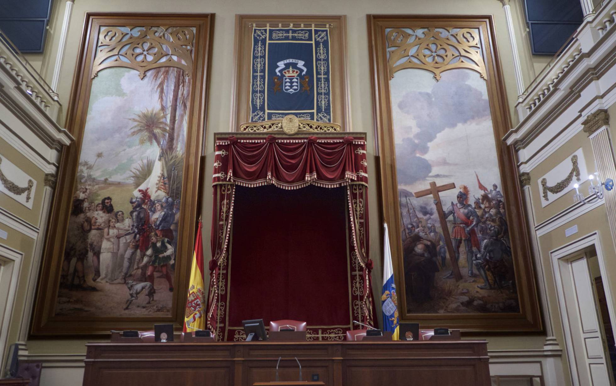 La mesa presidencial del Parlamento canario y los lienzos de la discordia: 'La entrega de princesa' (izquierda) y 'La fundación de las Santa Cruz de Tenerife'.