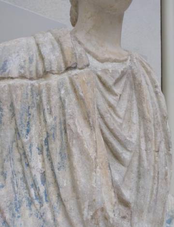 Detalle de la fractura entre el busto y el cuerpo y de los restos de policromía en la escultura.