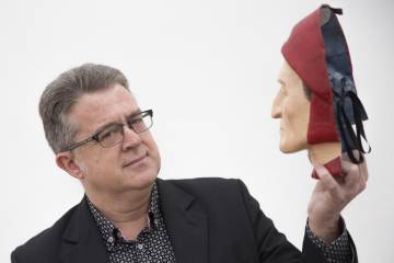 El catedrático y traductor José María Micó, sosteniendo una máscara de Dante Alighieri.