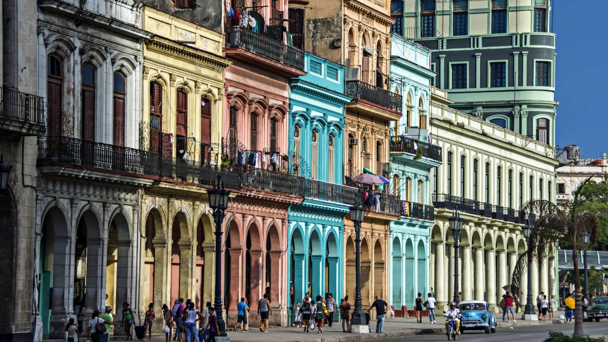 Turistas bajo los coloridos edificios con columnas en sus soportales en La Habana.