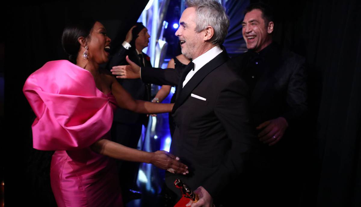 Cuarón (en el centro) recibe las felicitaciones de Angela Bassett y Javier Bardem.