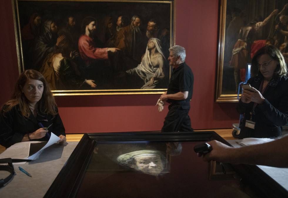 Técnicos del Prado revisan el autorretrato de Rembrandt antes de colgarlo.