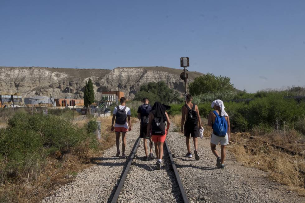 Un grupo de chavales camina por las antiguas vías del tren hacia el puente verde de La Poveda (Arganda del Rey).