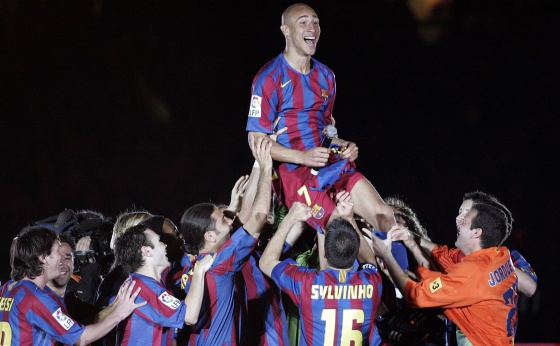 Larsson, manteado por los jugadores del Barça.