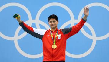Joseph Schooling posa com a medalha de ouro.